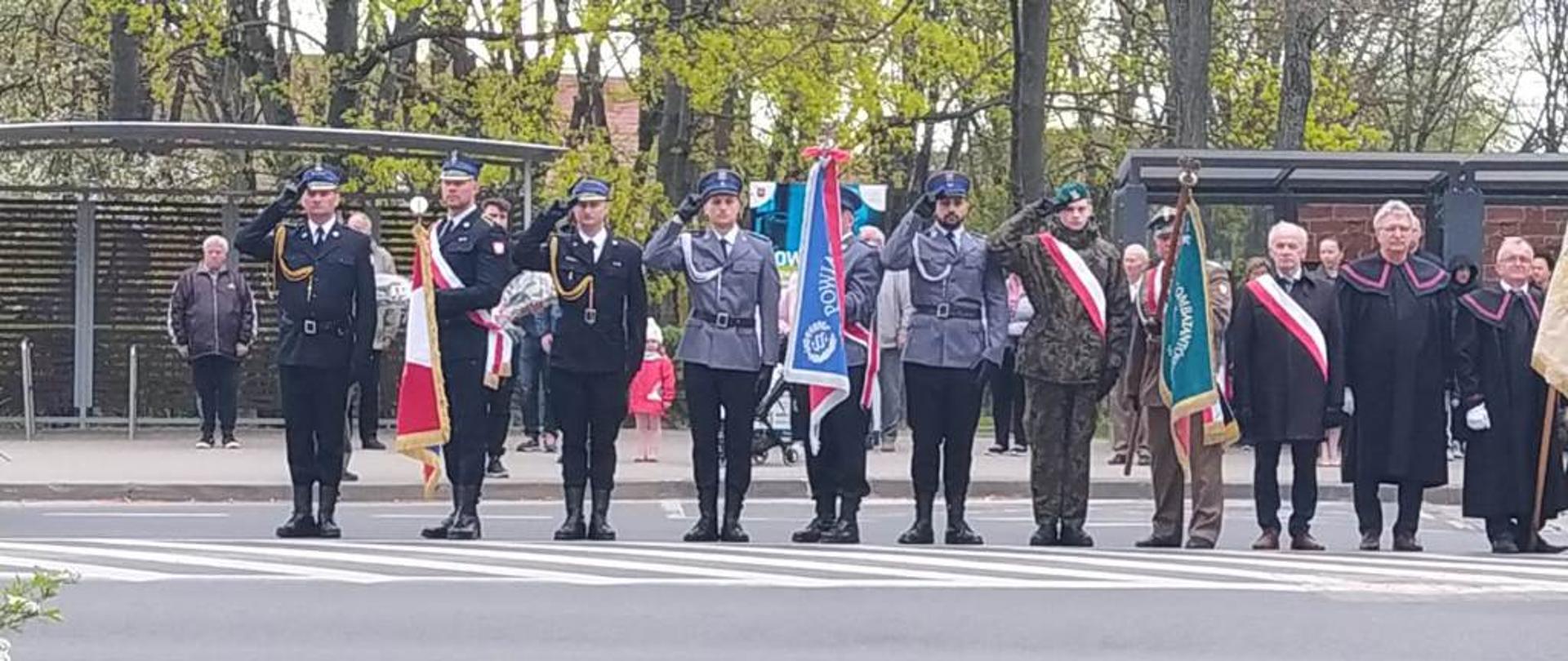 Poczty sztandarowe salutują podczas odgrywanego hymnu państwowego. 
