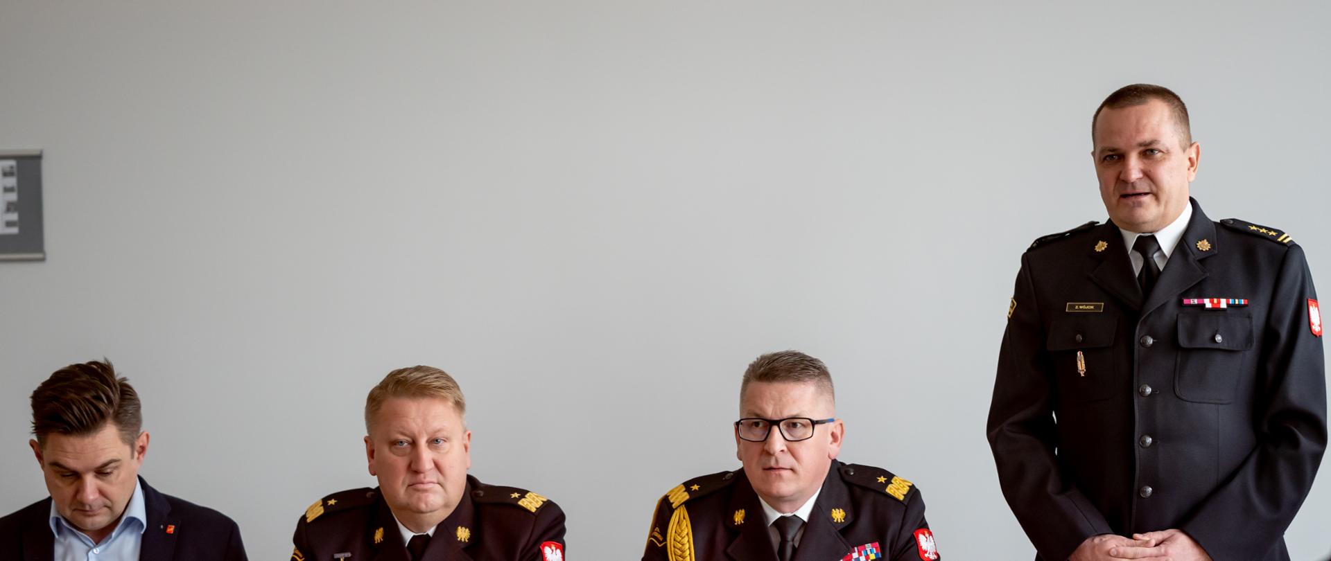 łódzki komendant wojewódzki PSP w Łodzi, zastępca komendanta głównego PSP w Łodzi siedzący za stołem, obok stojący komendant miejski PSP w Łodzi