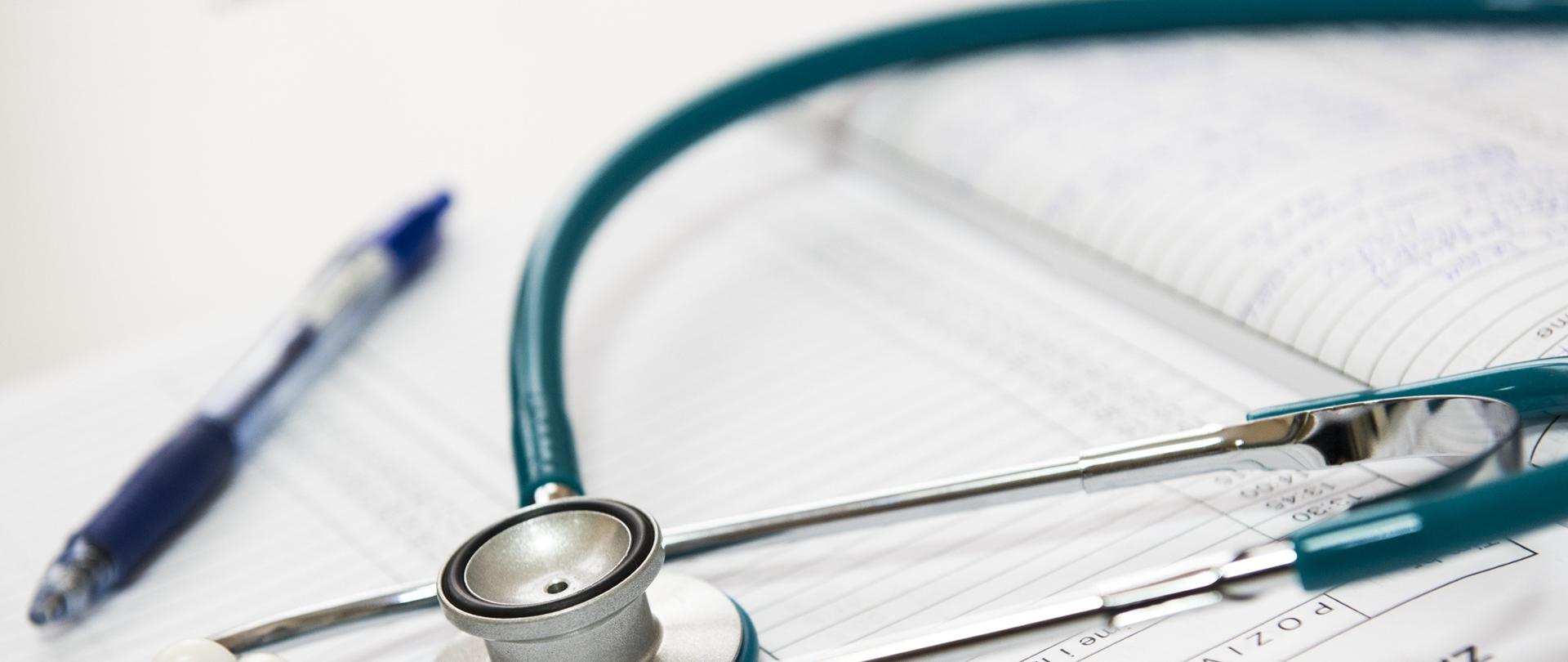 Na dokumentacji leży długopis i stetoskop