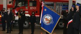 w garażu komendy PSP podczas apelu z okazji przekazania samochodów, po prawo poczet sztandarowy strażaków, na wprost marszałek Sejmu, po lewo od niej zastępca komendanta głównego oraz poseł na Sejm , za nimi w tle samochód ratowniczo - gaśniczy