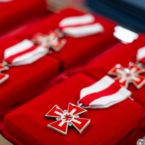 zdjęcie przedstawia zbliżenie na ordery na czerwonych aksamitnych pudełkach