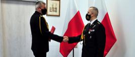 Zdjęcie przedstawia pomorskiego komendanta wojewódzkiego PSP st. bryg. Piotra Sochę wręczającego decyzję o powołaniu na komendanta powiatowego PSP w Kartuzach st. kpt. Pawłowi Gilowi.