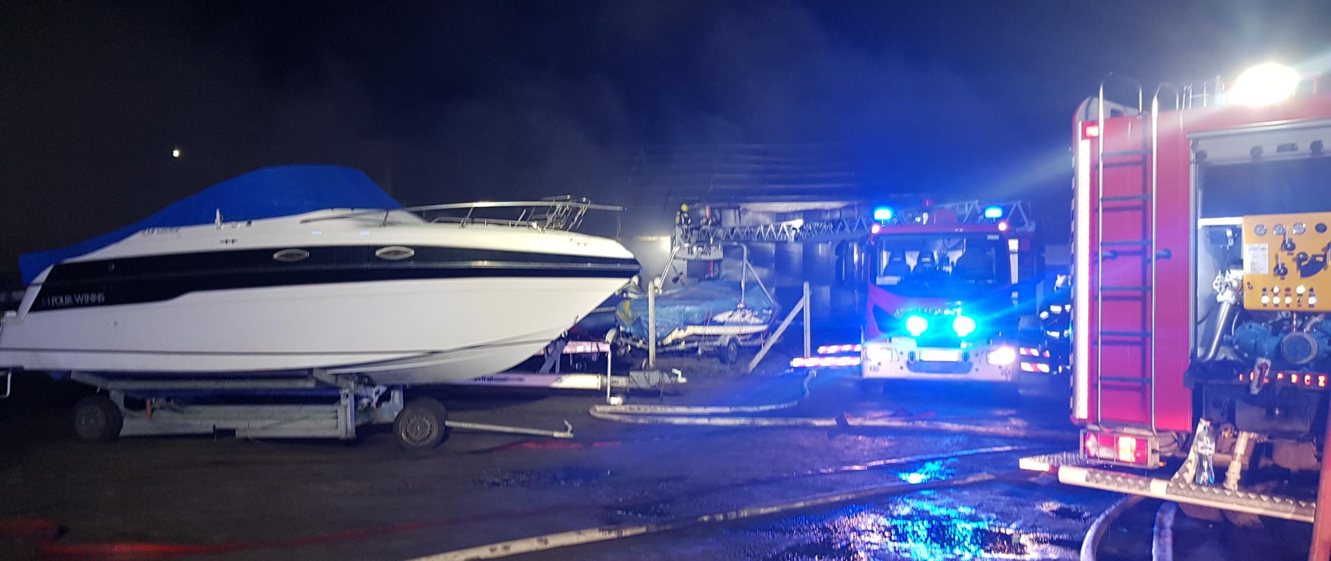 Na zdjęciu widać strażaków, wozy strażackie oraz uratowany jacht 