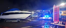 Na zdjęciu widać strażaków, wozy strażackie oraz uratowany jacht 