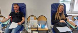 Na zajęciu widoczni mężczyzna w czarnej koszulce i jeansach oraz kobieta w czarnej koszulce i spodniach koloru czarnego siedzący na fotelach na sali oddający krew podczas akcji zbiórki krwi zorganizowanej przez Klub Honorowych Dawców Krwi Polskiego Czerwonego Krzyża przy Komendzie Powiatowej Państwowej Straży Pożarnej w Gorlicach 