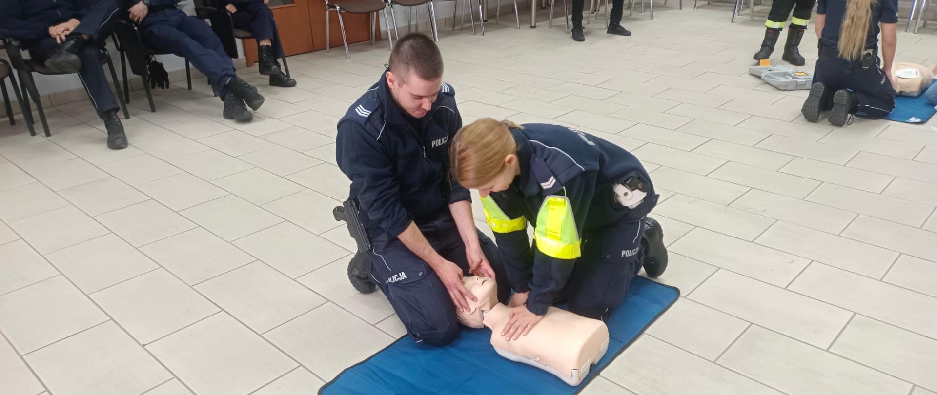 Dwie osoby z Policji udzielają pierwszej pomocy na fantomie