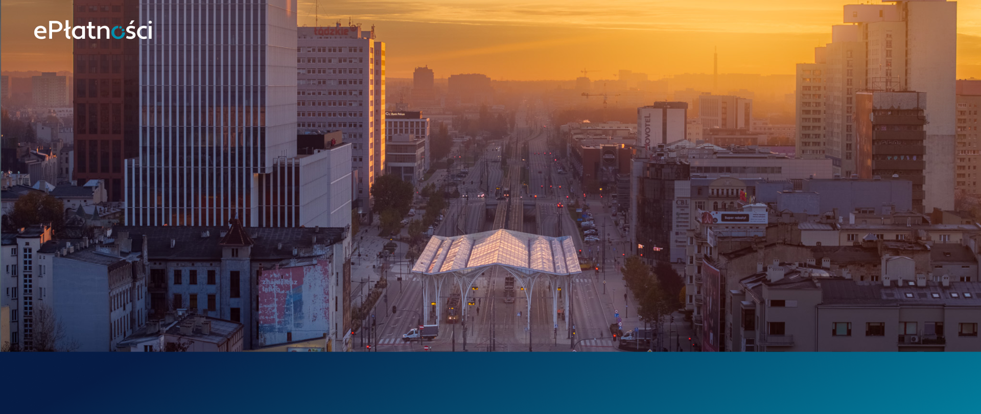 Ujęcie z lotu ptaka. Łódź widok na tzw. stajnię jednorożców o zachodzie słońca. Na środku metalową wiata, pod którą wjeżdżają tramwaje. Wokół stare kamienice i wieżowce.