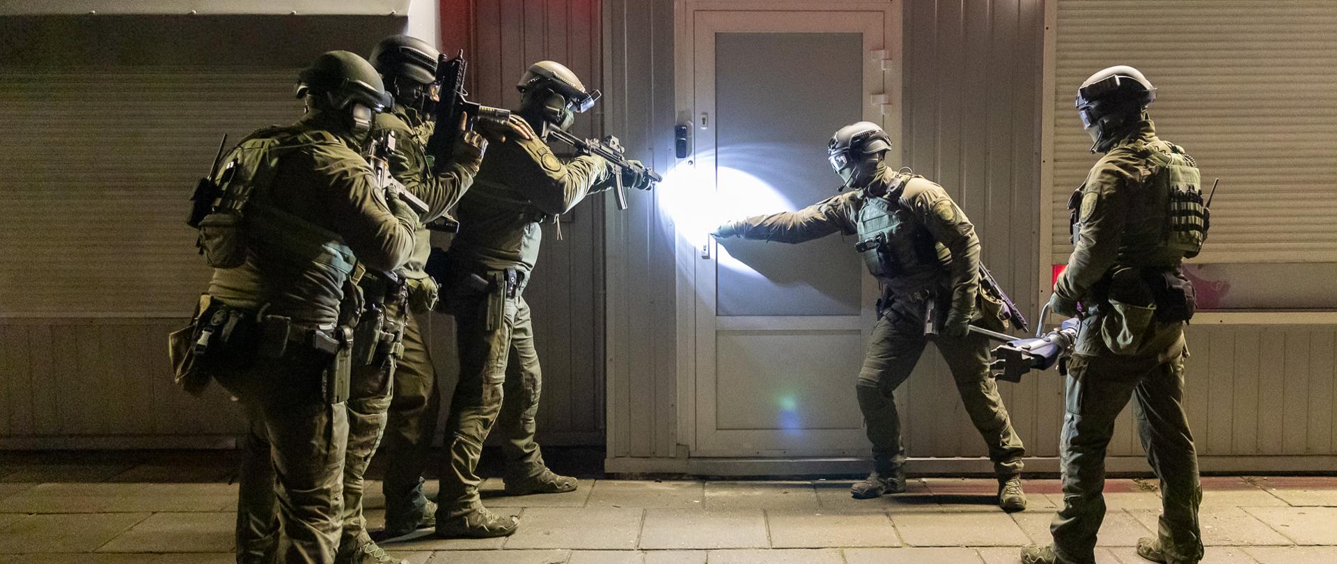 Funkcjonariusze z KAS przed wejściem do nielegalnego punktu hazardowego.