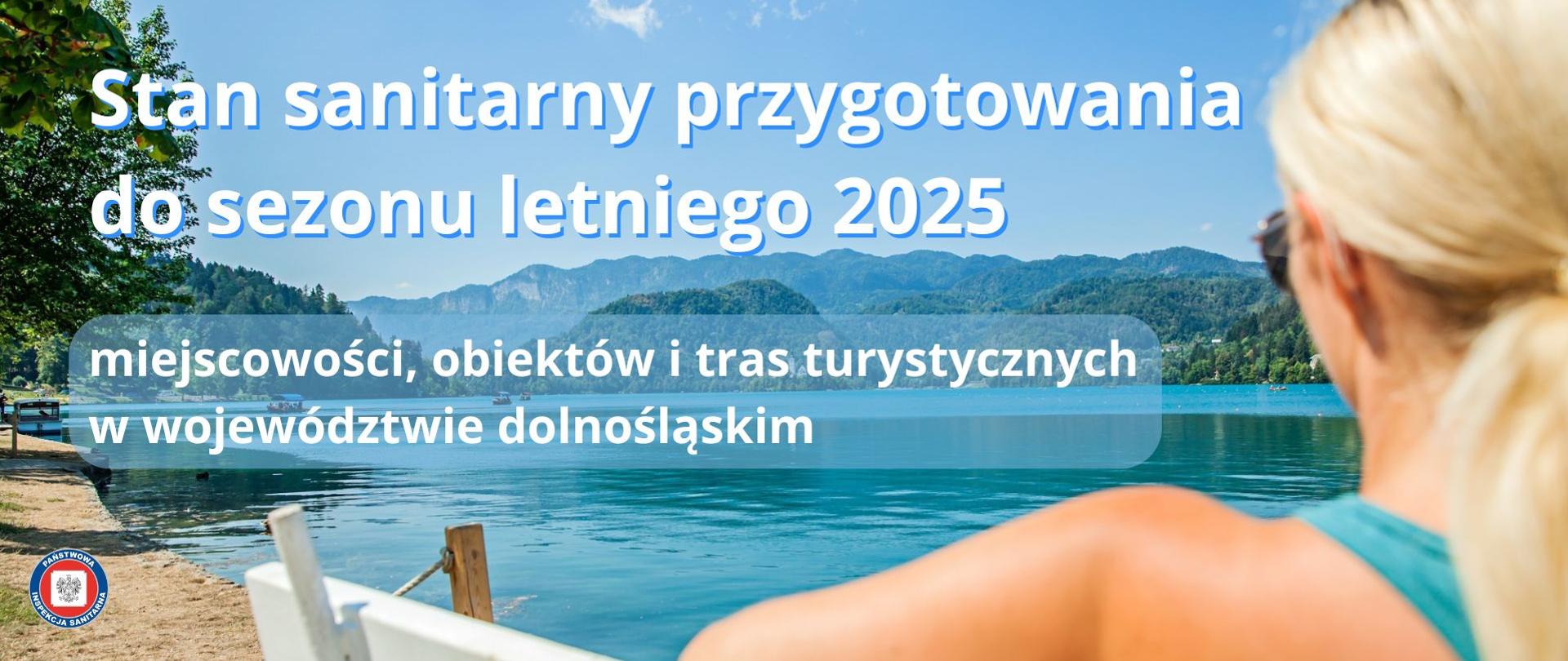 Kobieta siedząca na ławce nad brzegiem błękitnego jeziora. W tle góry porośnięte lasami. 