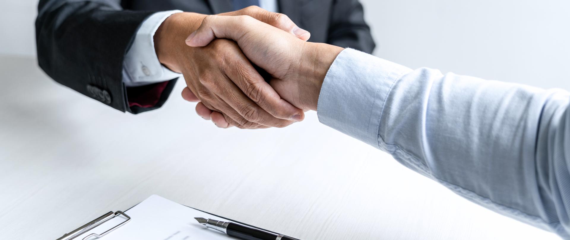 Greeting new colleagues, Handshake while job interviewing, male candidate shaking hands with Interviewer or employer after a job interview, employment and recruitment concept.