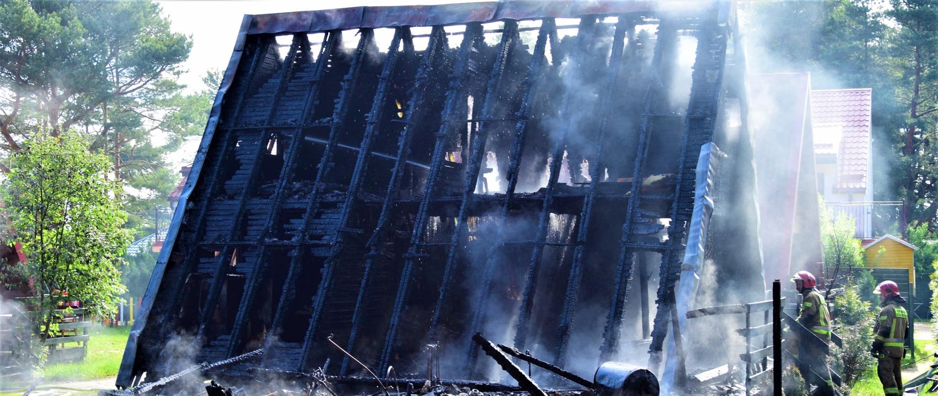 Zdjęcie przedstawia spalony domek letniskowy.
