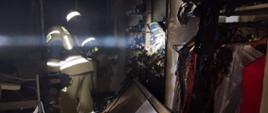 Spalone wnętrze mieszkania oraz strażak w aparacie ODO