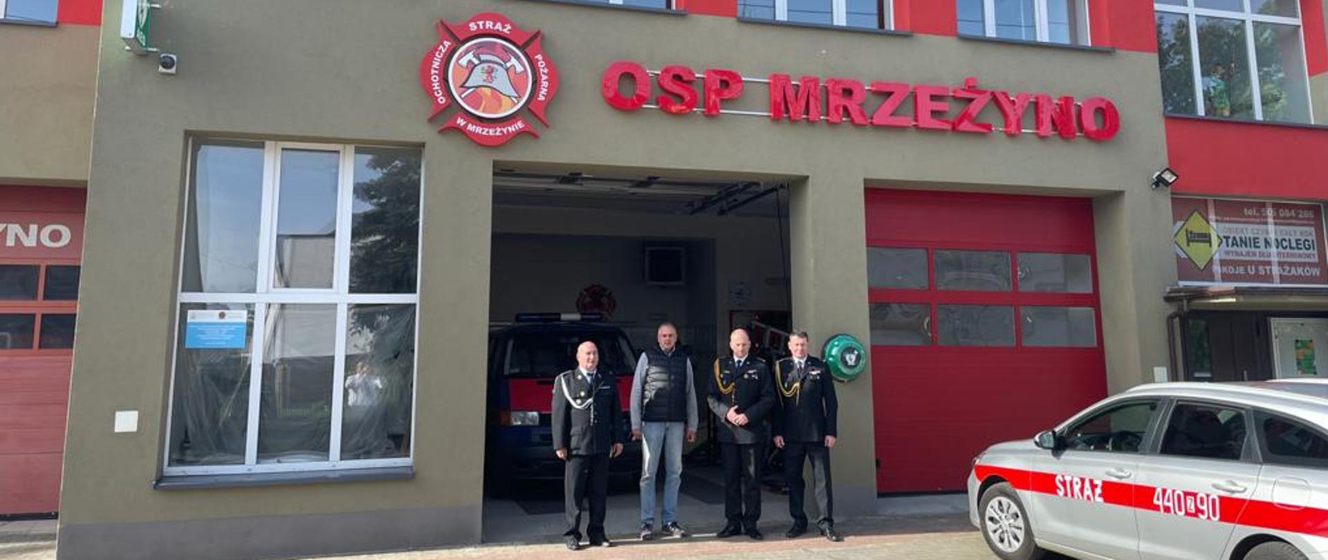 Komendanci stoją przez remizą OSP Mrzeżyno, na bliższym planie SOp 440-90 z KP PSP Gryfice