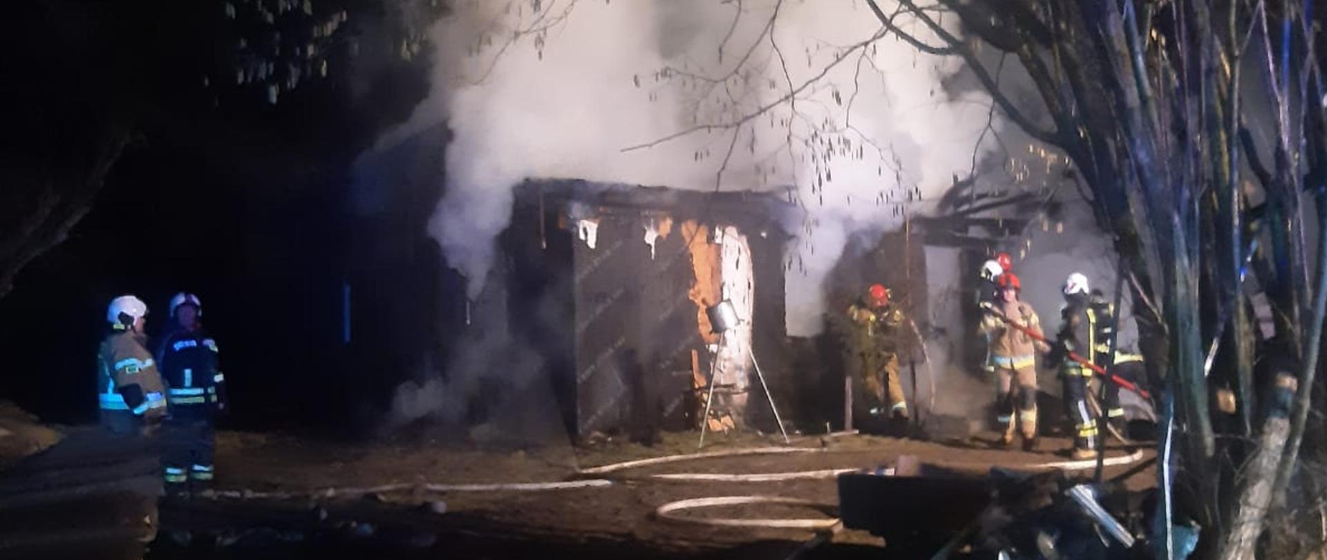 Na zdjęciu widać pożar budynku mieszkalnego oraz strażaków