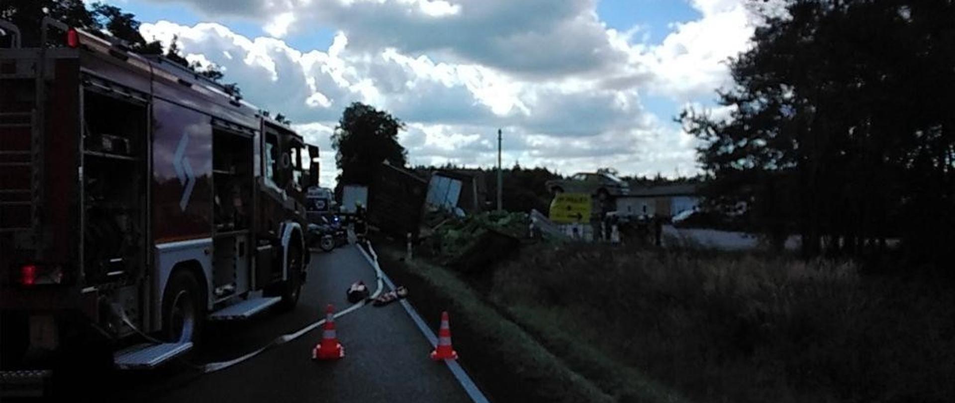 Wypadek samochodu ciężarowego, na pierwszym planie samochód pożarniczy.