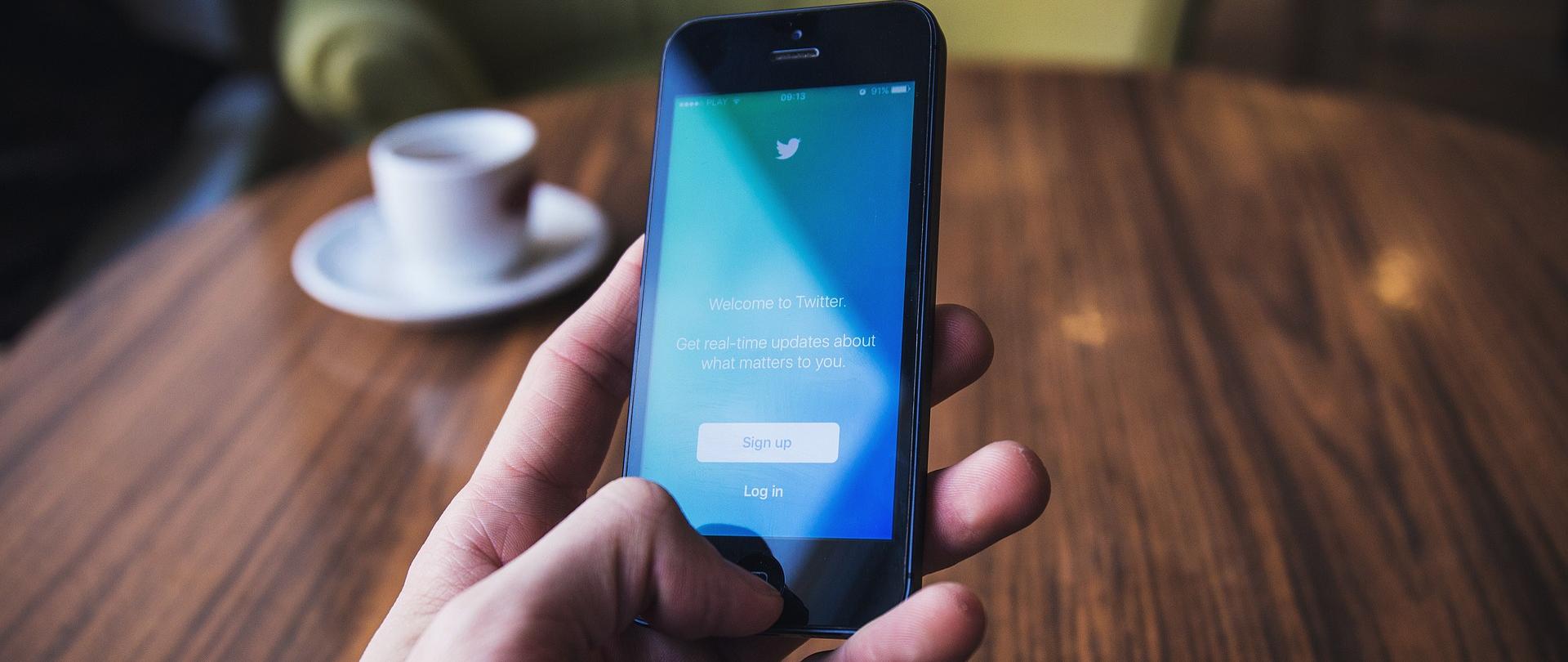 telefon komórkowy z wyświetloną stroną startową aplikacji Twitter